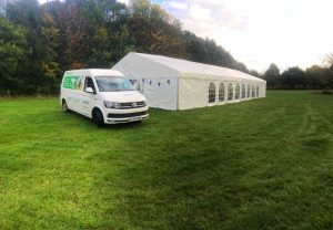 Marquee Hire Cambridge van parked infront of a marquee on a green field